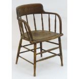 An early 20thC smokers bow chair with turned finial supports and anthemion decorated seat,