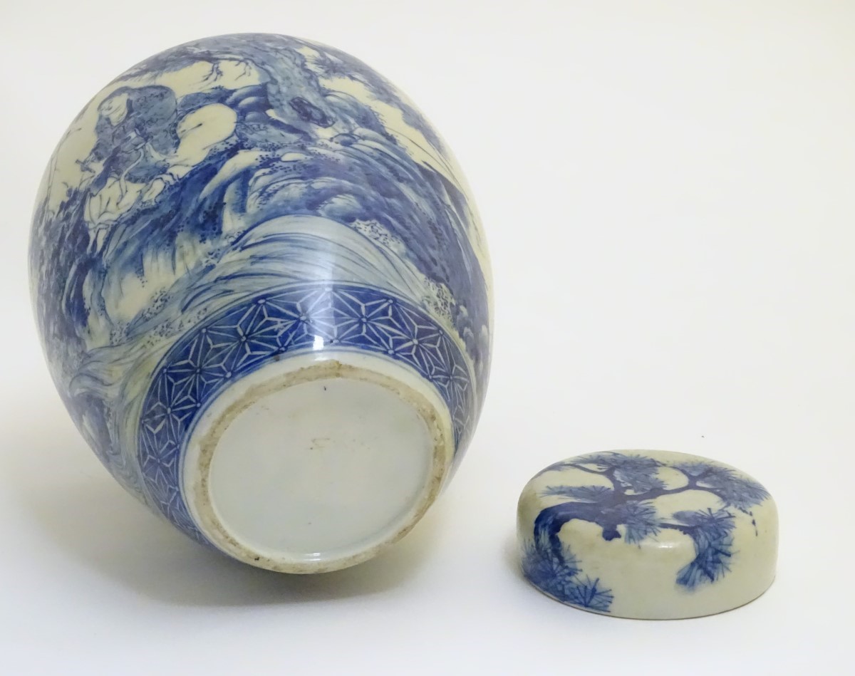 A large blue and white Japanese lidded ginger jar decorated with a sage sat by a tree in a - Image 7 of 7