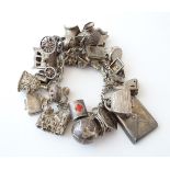 A silver and white metal charm bracelet with various charms including a silver carriage,