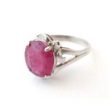 An 18ct white gold ring set with central red spinel flanked by diamonds.