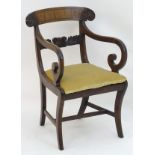 An early / mid 19thC mahogany open armchair with a carved top rail with ebonised inlay and floral
