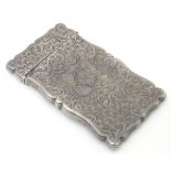 A silver visiting card case with engraved acanthus scroll decoration.