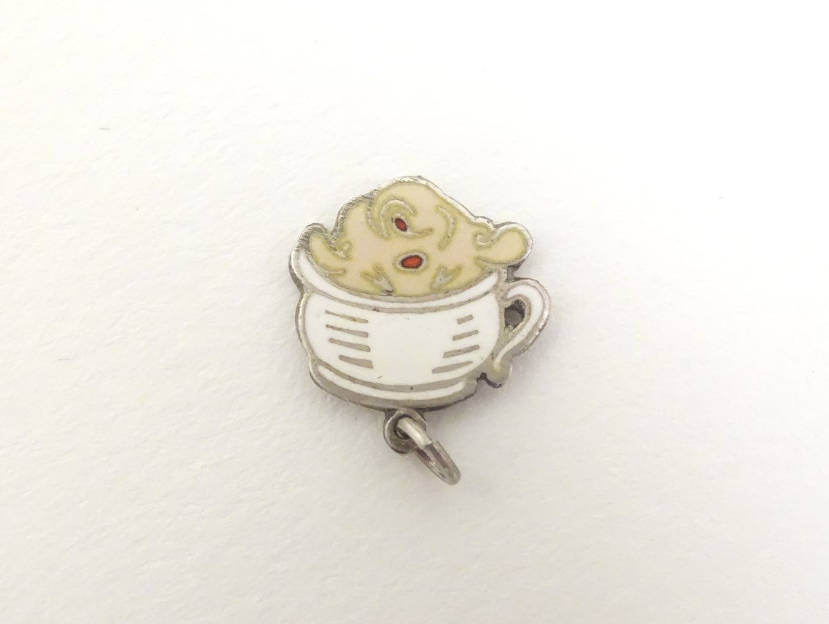 A mid 20thC novelty white metal pendant charm formed as a humorous face wearing a chamber pot as a - Image 2 of 5