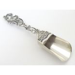 A Continental .800 silver caddy spoon with scroll decoration to handle.