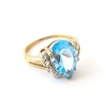 A 9ct gold ring set with pear cut topaz flanked by white stones. Ring size approx.