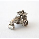 A novelty white metal charm formed as vintage steam roller.