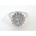 A 9ct white gold ring set with central aquamarine bordered by cubic zirconia. Ring size approx.