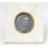 A late 19thC oil on board oval miniature portrait of a young girl. Image approx.