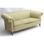 A late 19thC Chesterfield sofa raised on square legs terminating in brass castors.