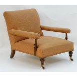 A late 19thC low open armchair with turned supports and raised on walnut turned front legs