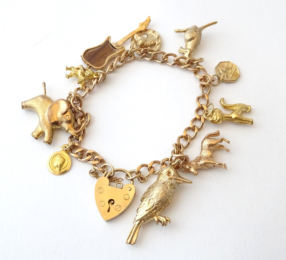 A 9ct gold charm bracelet set with various 9ct and yellow metal etc charms.