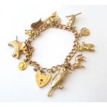 A 9ct gold charm bracelet set with various 9ct and yellow metal etc charms.
