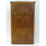 A late 18thC / early 19thC oak corner cupboard with a bowed back,