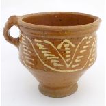 An 18th / 19thC French jug / vessel with a side handle and narrow base, with slipware decoration.