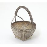 A white metal dish formed as a woven basket.