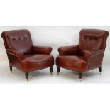 A pair of red leather armchairs with deep buttoned back rests,
