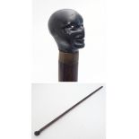 A walking stick / cane with a carved ebonised pommel formed as a male negro human head with an