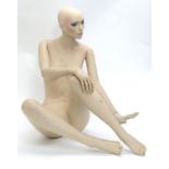 A 20thC female seated shop display mannequin with articulated, posable limbs. Seated height approx.