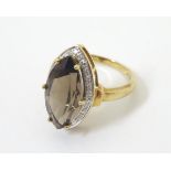 A 9ct gold ring set with marquise cut brown stone bordered by diamonds. Ring size approx.