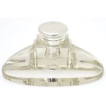A glass standish / inkwell of ovoid form, with pen rest and silver mounted and lidded inkwell,