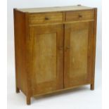 An early / mid 20thC oak 'Heal & Son' cabinet with two short drawers above two cupboard doors.