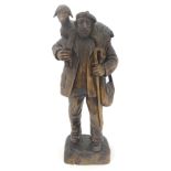 A carved wooden sculpture in the Black Forest style depicting a Scottish shepherd wearing a