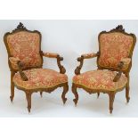 A pair of French mid 19thC walnut open armchairs with carved cresting rails above shaped backrests,