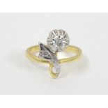A 18ct gold ring set with 2 diamonds in a stylised floral setting. The largest diamond approx .20ct.