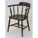A late 19thC smokers bow chair with ring turned supports and standing on legs united by a double
