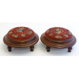 A pair of Victorian mahogany footstools with overstuffed beadwork tops and moulded frames raised on