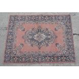 Carpet rug :a machine made pink ground small carpet with grey, black , buff and cream colours ,