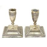 A pair of Victorian silver candlesticks with floral decoration.