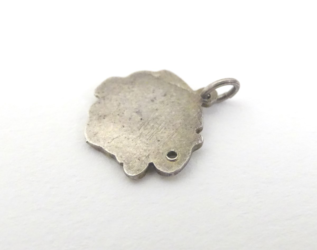 A mid 20thC novelty white metal pendant charm formed as a humorous face wearing a chamber pot as a - Image 5 of 5