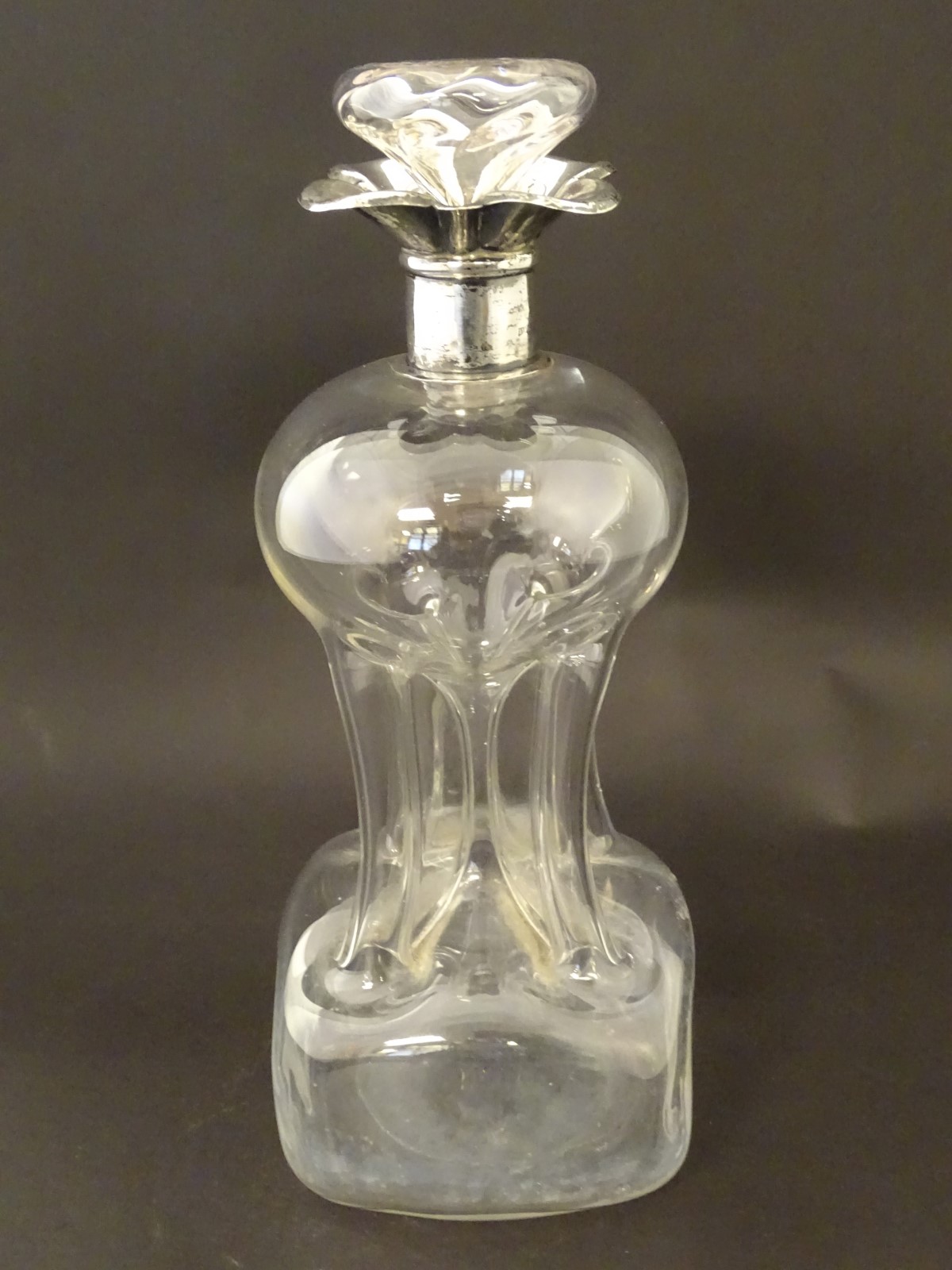 A glass decanter with pinch waist detail and silver rim hallmarked Birmingham 1906. 11" high