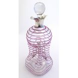 A Victorian decanter with pinch detail and purple trailed decoration.