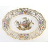 An oval basket dish with a reticulated floral border with gilt highlights,