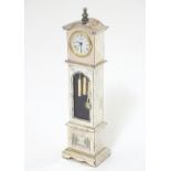 A novelty mantle cock formed as a miniature silver plate long case / grandfather clock.