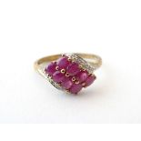 A 9ct gold ring set with 8 red spinel flanked by chip set diamonds. Ring size approx.