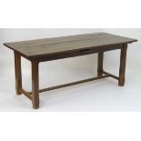 An early 20thC oak refectory / dining table with a large rectangular planked top above a single