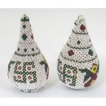A pair of wooden pear shaped decorations with beadwork featuring Buddhist symbols of good luck.