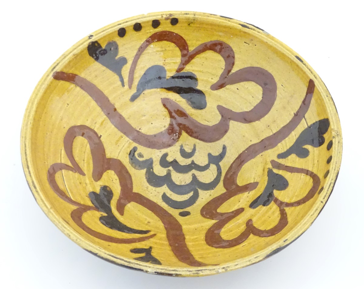 A 19thC slipware bowl with stylised foliate decoration. Approx. 2 ½” high x 7 ½” diameter.