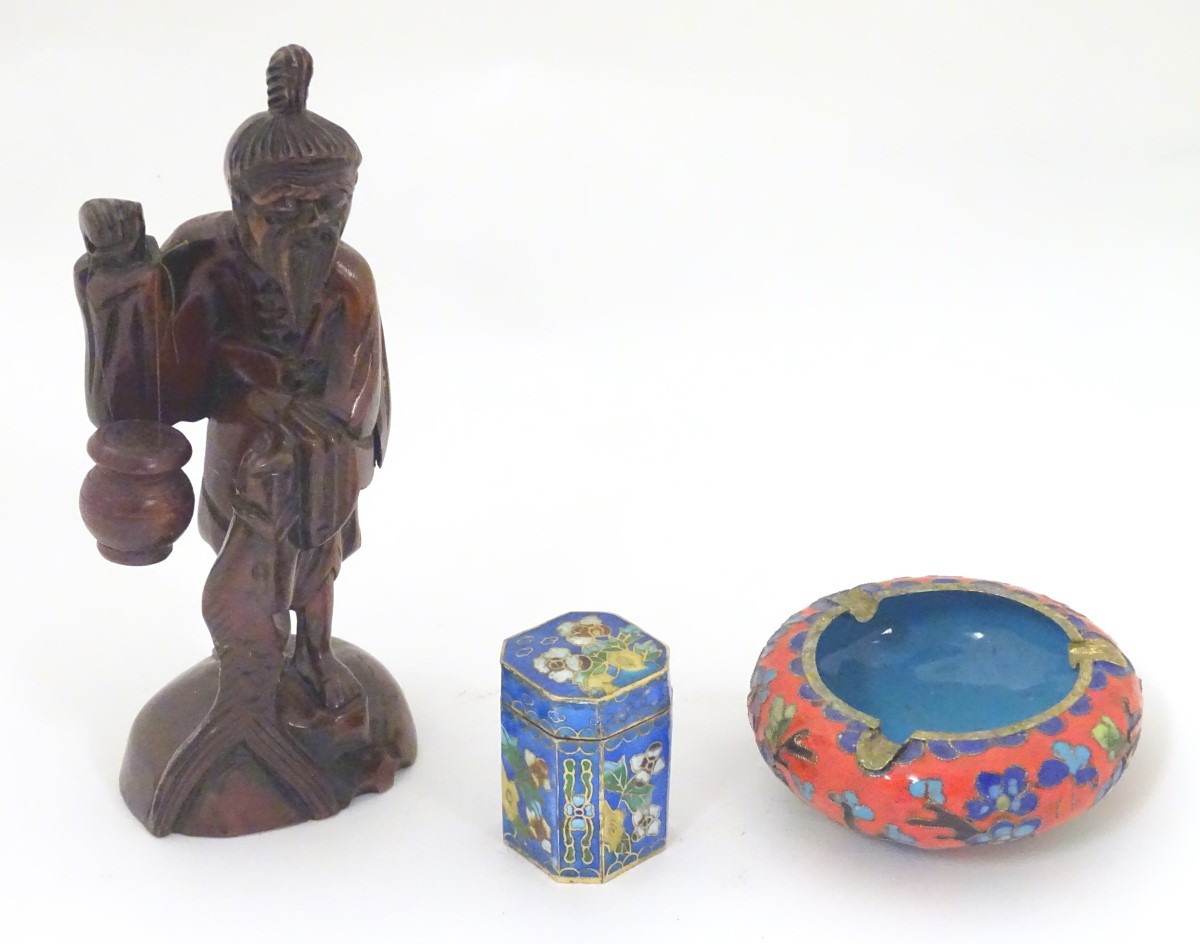 Three assorted oriental items, to include a carved figure with a fish and hanging pot,