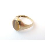 A 9ct gold gentleman's ring set with tigers eye cabochon. Ring size approx.