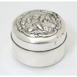 A silver pot and cover with embossed scene to lid.