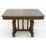 A 20thC oak dining table standing on fluted tapering supports and having central turned columns