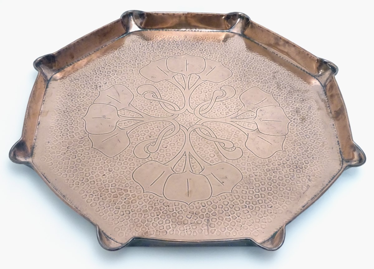An Arts & Crafts octagonal copper charger / tray with incised natural form decoration and a shaped