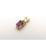 A 9ct gold pendant set with oval cut amethyst. the stone 1/4" log, the pendant 1/2" long overall.
