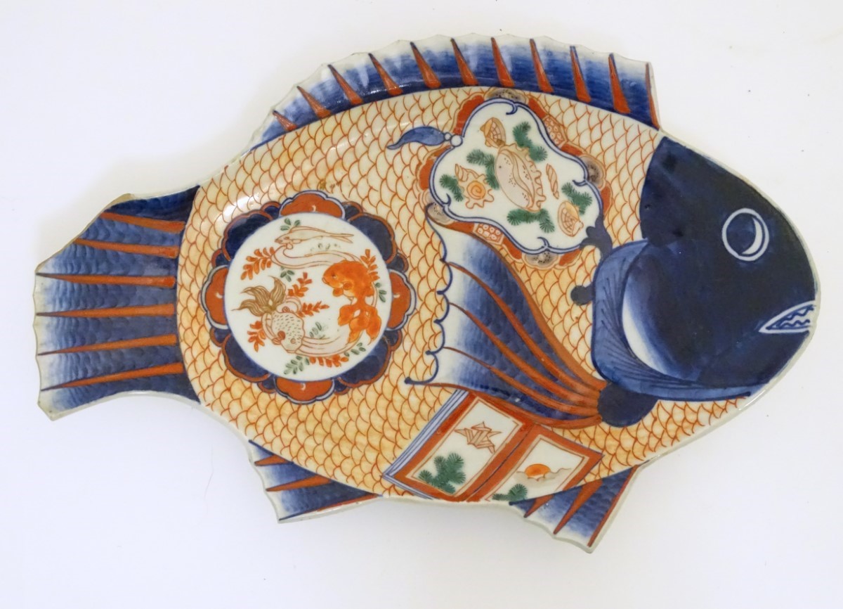 An Imari dish formed as a fish, decorated with panels depicting shells and fish,