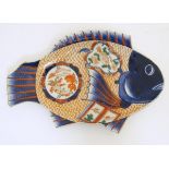 An Imari dish formed as a fish, decorated with panels depicting shells and fish,