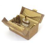 A 20thC leather necessaire / travelling vanity case, the case comprising 6 gilt metal items,